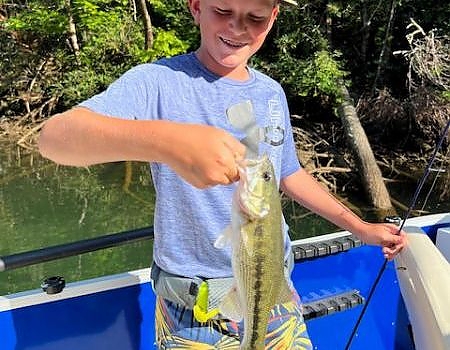 Boy holds up fish caught on Blue Ridge fly-fishing trip