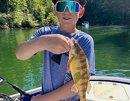 Boy poses with catch during Blue Ridge fly-fishing trip