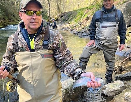 Men poses with fish caught on fly fishing trip