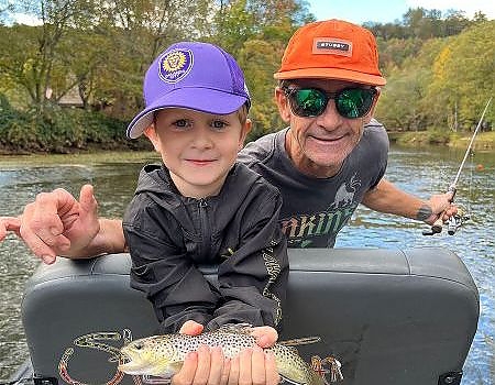 Boy and father pose with fish caught on fly fishing trip